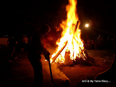 Taking of coconut prasad from the Holika Dahan bonfire