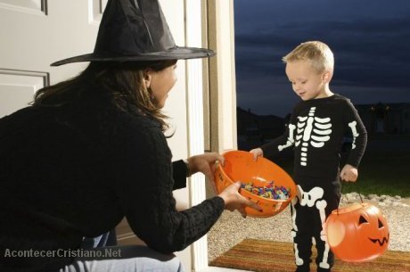 Niño disfrazado recibe caramelos en Halloween
