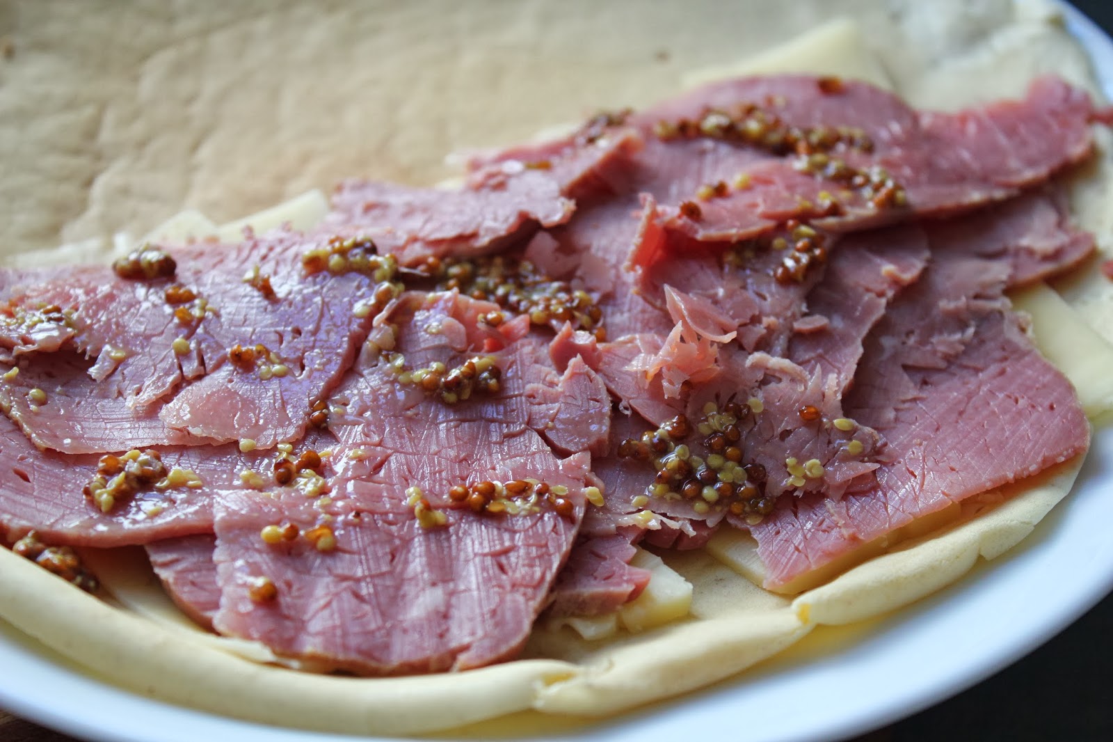Rye crepes with cheese, corned beef, and mustard