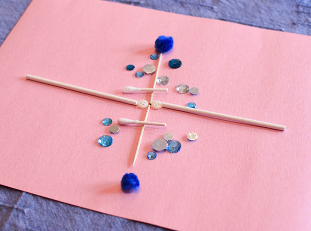 Winter STEM- Build A Snowflake Tinker Tray.  Use loose parts to build snowflakes.  Explore radial symmetry as you incorporate math, science, fine motor work, and creativity in this activity for preschoolers, kindergartners, and elementary school.