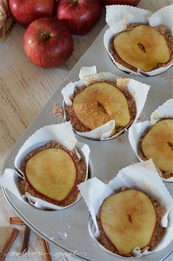Top each apple muffin with crumb topping and a slice of apple | www.andersonandgrant.com