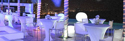 montaje de Recepción Tipo Cocktail en terraza con luces neon y manteleria de color blanco