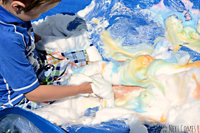 Kid playing in colored shaving cream