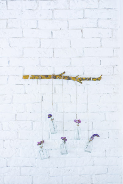 Rama con botellas de cristal y flores