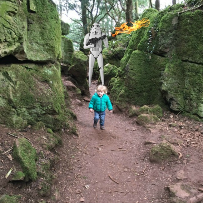 picture-of-toddler-on-narrow-path-between-rocks-with-stormtrooper-holding-flaming-gun-behind