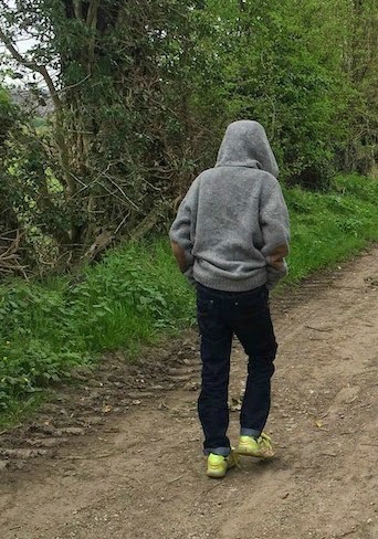 Morgan's Milieu | The First Signs of Puberty: A hooded figure walking through countryside.