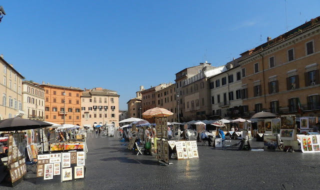 There are many artist booths set up in the Piazza