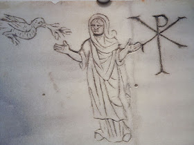 etching of a Christ figure, Chi-Roh symbol and dove that was recovered from the catacombs