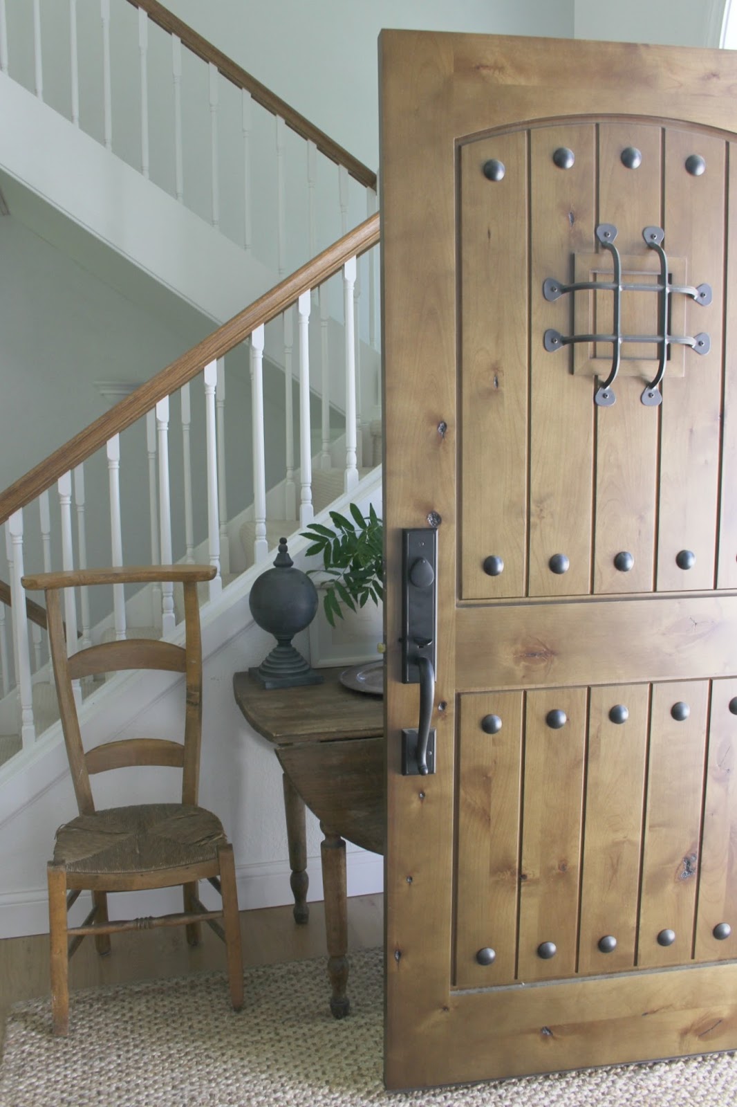 Hello Lovely's rustic knotty alder wood front door with speakeasy.