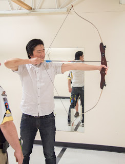 Hwan shooting a bow and arrow.