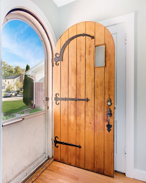 round top 1930s style vintage Sears door with iron strapping with curylcues on hinge end