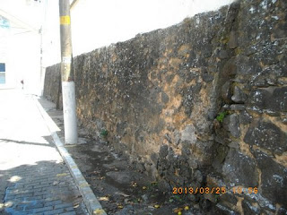 O esgoto escorre do muro de pedras
