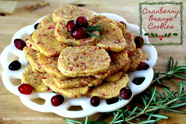 Christmas Cookies | White plate piled with cranberry orange cookies and whole cranberries on a wooden table with a sprig of fresh rosemary | rosevinecottagegirls.com