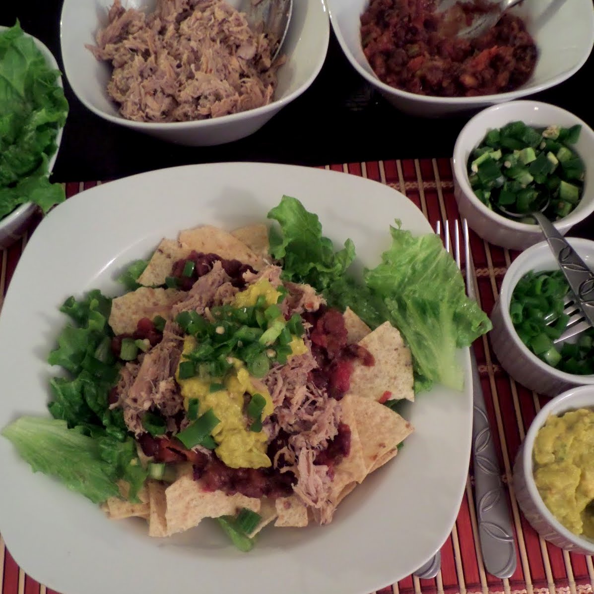 Pulled Pork Taco Salad:  A taco salad topped with spicy black beans, pulled pork, and avocado.