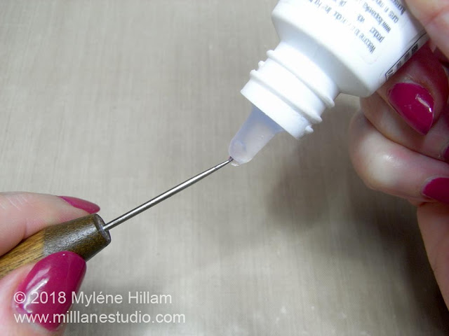 Applying one drop of UV resin to the point of the needle tool.