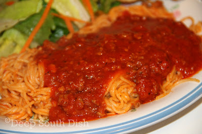 Plated spaghetti with homemade fresh tomato sauce spooned on top.