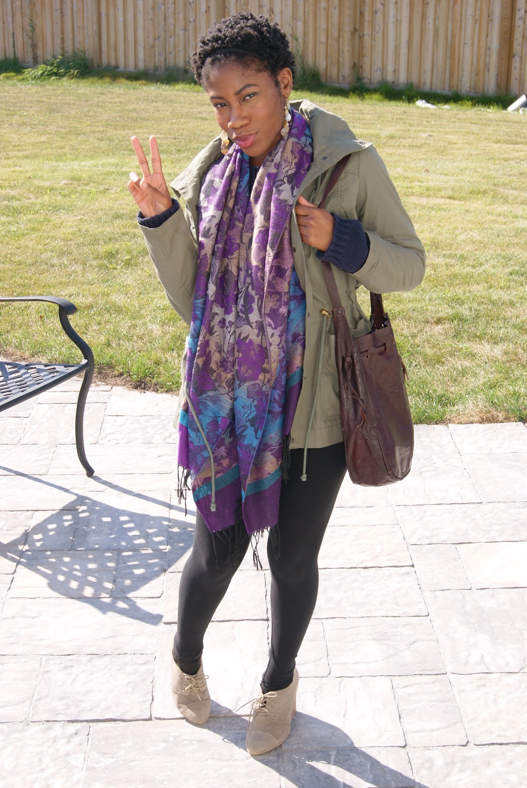 wearing a black long seelve top, a navy blue sweater, a scarf and a light jacket