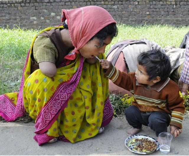niño de dos años da de comer a su madre con discapacidad