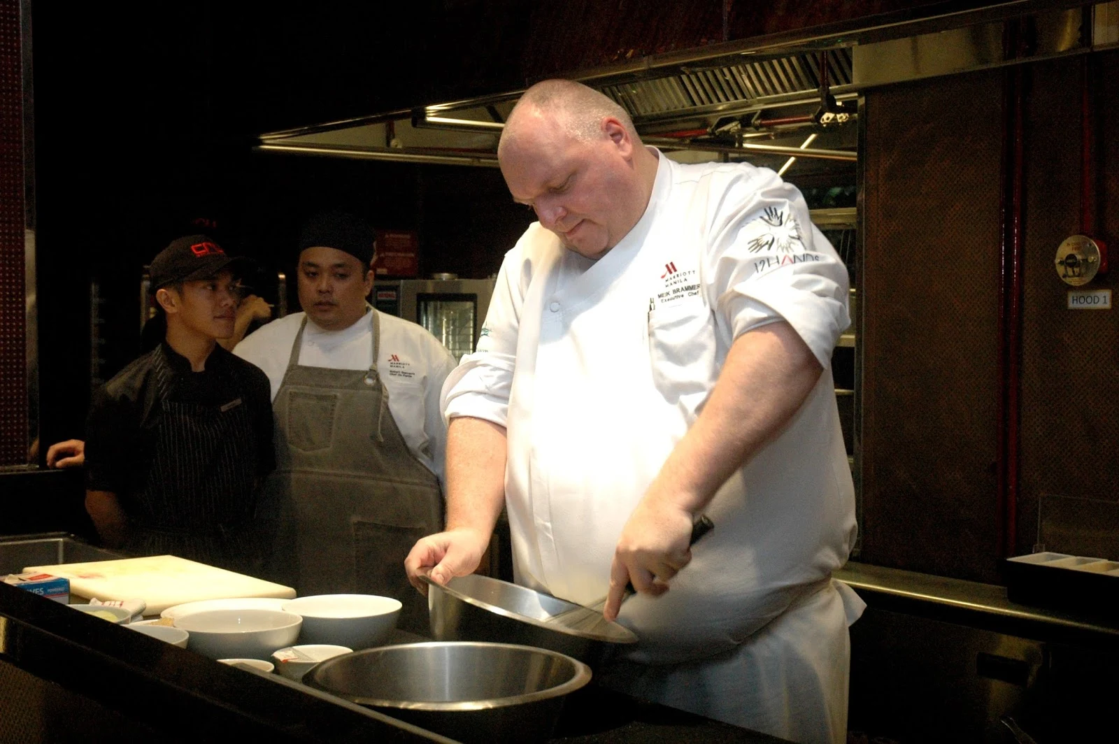A chef holding a mystery box with a questioning expression