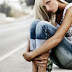 Young blonde sitting by the road
