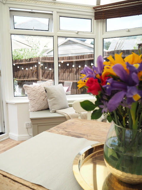 Turn an old unused conservatory into a stylish sunroom with dining table and chairs and blanket box seating area from The Cotswold Company
