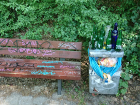 Reste einer Party am See Krumme Lanke. Eine Graffitti-beschmierte Bank und Alkoholflaschen aus dem Mülleimer.