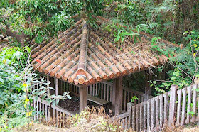 Tiled-roof building overlooking waterfall, benches, fence and railings