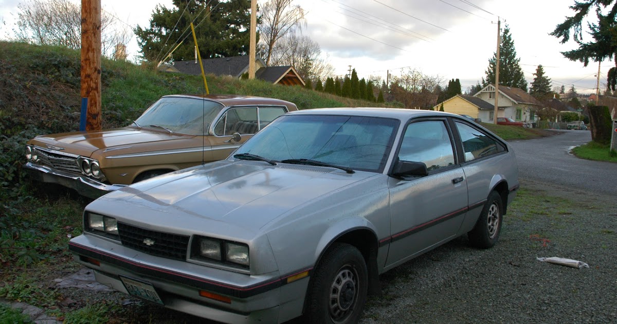 OLD PARKED CARS.: 1984 Chevrolet Cavalier F-41 and 1961 Chevy Impala.