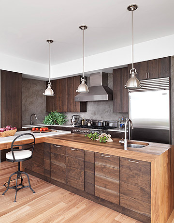 A modern walnut kitchen with blue bar stools and stainless steel appliances