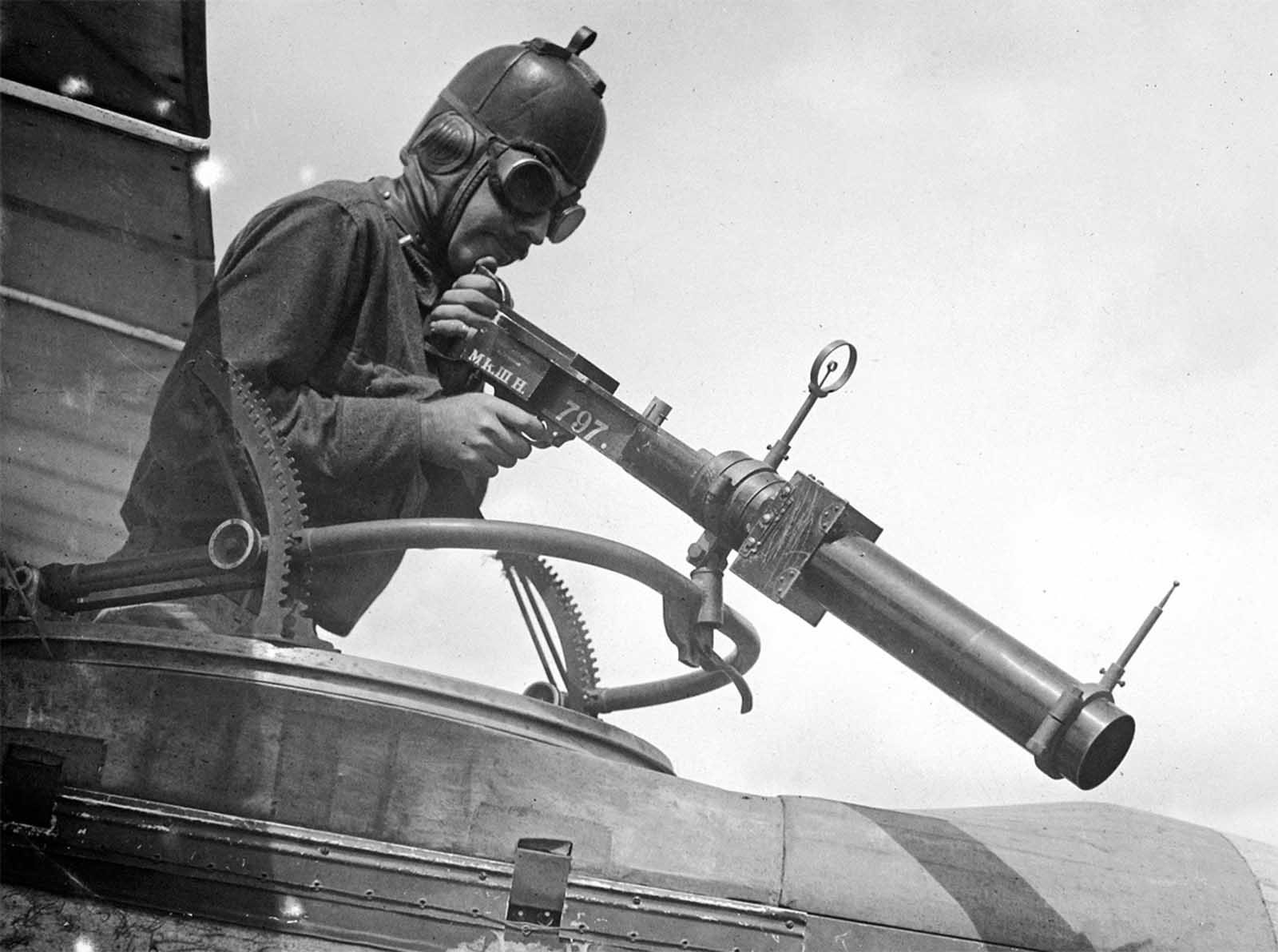 A soldier poses with a Hythe Mk III Gun Camera during training activities at Ellington Field, Houston, Texas in April of 1918. The Mk III, built to match the size, handling, and weight of a Lewis Gun, was used to train aerial gunners, recording a photograph when the trigger was pulled, for later review, when an instructor could coach trainees on better aiming strategies.