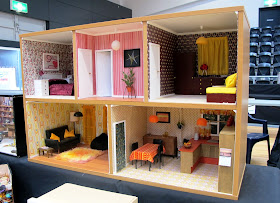 Modern dolls' house miniature 1970s-style house in a bookcase.
