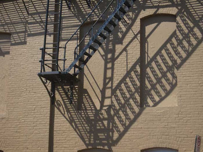 Shadows of fire escapes on a brick building