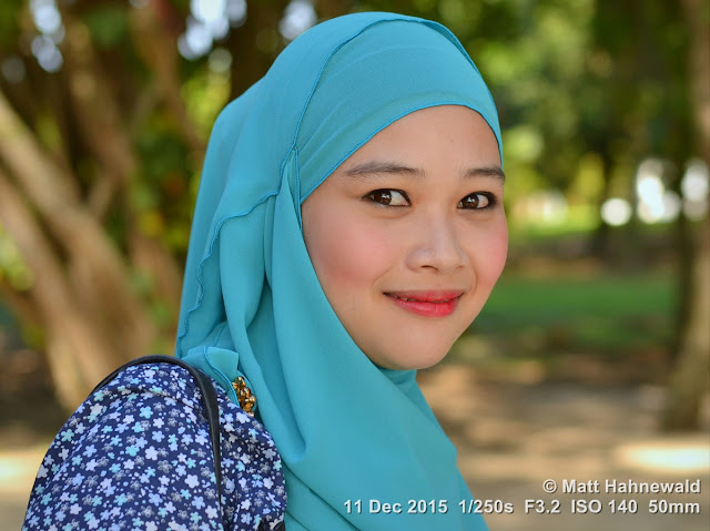 Close-up street portrait (outdoor headshot) of a beautiful, young Muslim woman from Malaysia, wearing a turquoise hijab; Kuah, Langkawi, Malaysia. Matt Hahnewald Photography; Facing the World; closeup; street portrait; headshot; outdoor; Asia; Southeast Asia; Malaysia; Langkawi; Kuah; smiling; beautiful; Malay woman; hijab; red lips; posing; beach; makeup; stylish; 1Malaysia