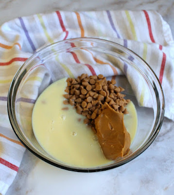 sweetened condensed milk, peanut butter chips and peanut butter in glass bowl ready to cook into fudge