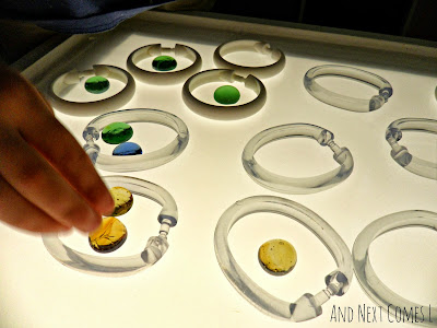 Shower curtain rings and glass stones on the light table from And Next Comes L