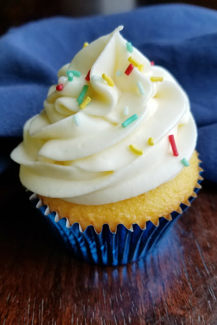 This silky smooth Russian buttercream is made with sweetened condensed milk and flavored with lemonade. Pipe some on lemon cupcakes for an luscious lemon treat! tall puffy swirl of lemonade frosting on cupcake