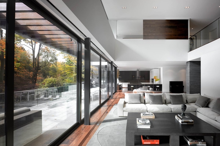 Living room with glass wall in Modern mansion by Belzberg Architects Group