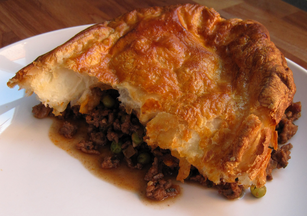 Minced beef and onion pie on a serving plate.
