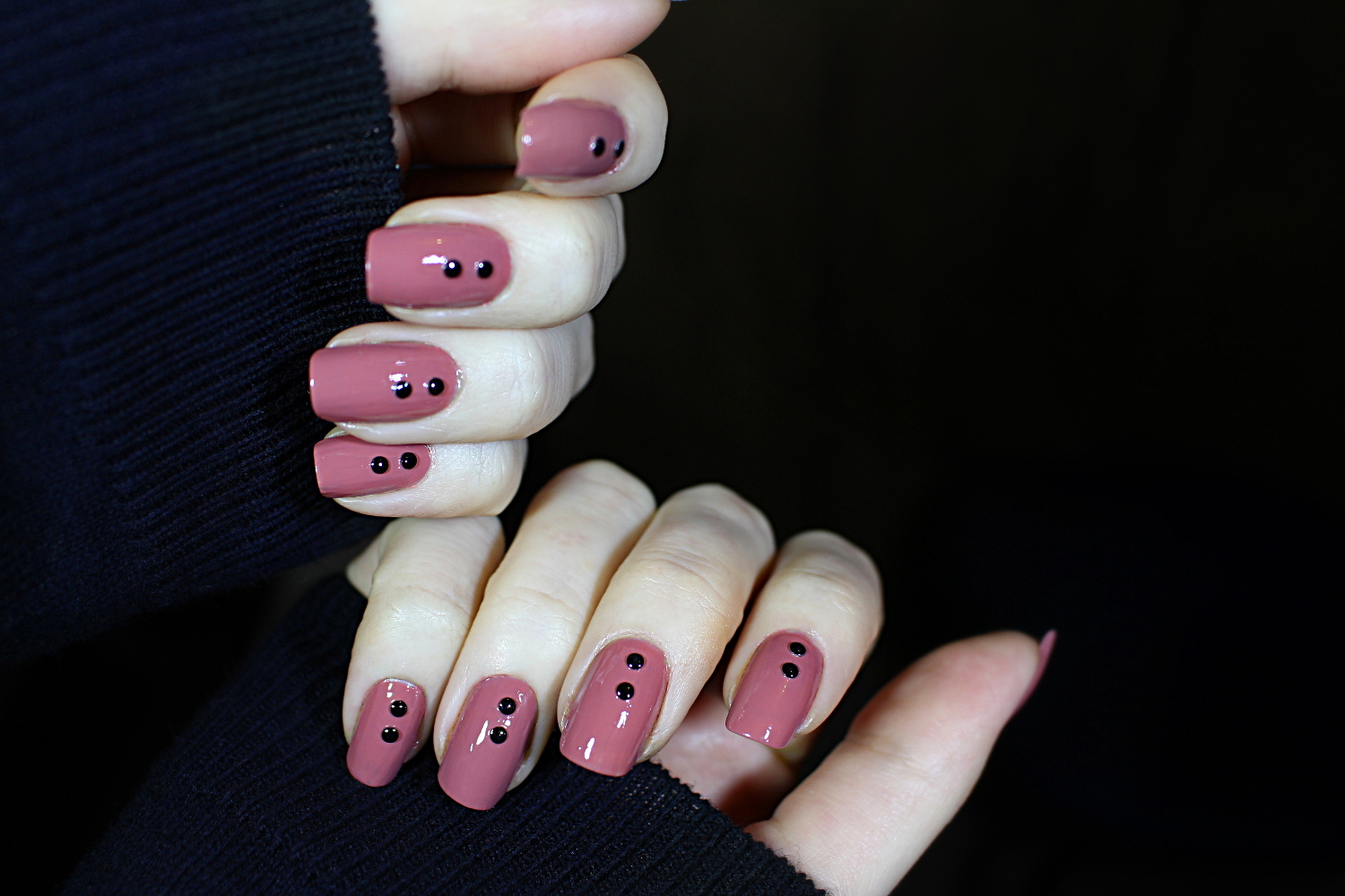 close-up of a simple, punk style nail look on short nails decorated with studs