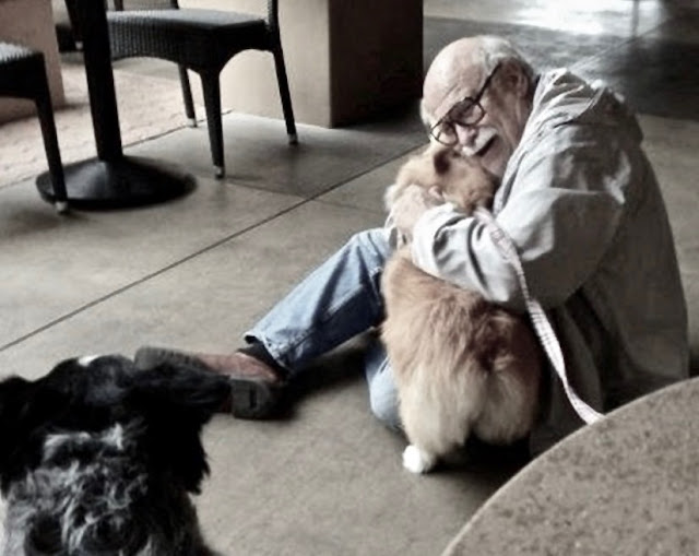 A senior sits on the floor, hugging a therapy dog. Gratitude and other stories of giving thanks. marchmatron.com A senior sits on the floor, hugging a therapy dog. Gratitude and other stories of giving thanks. marchmatron.com