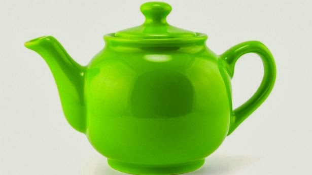чайник с чаем. чайник на зеленом фоне. зеленый чай. зеленый чай. серый чайник на зеленом фоне.