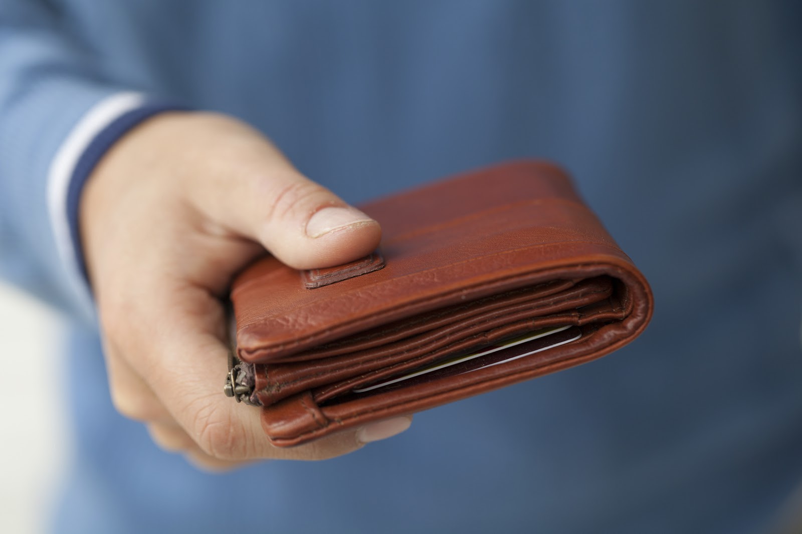 наличные в кошельке. женщина с пустым кошельком. пустой кошелек. закрывает кошелку. деньги тенге в кошельке.