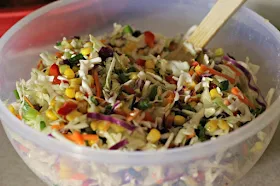 Firecracker Coleslaw by Renee's Kitchen Adventures mixed up in a white bowl with a serving spoon