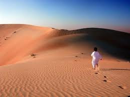 criança caminhando pegadas no deserto