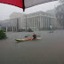 White man seen in a boat paddling through the flooded streets of Victoria Island (Photos)