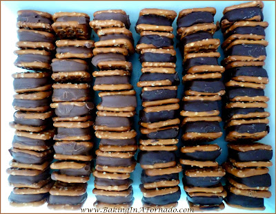 Pretzel Sandwich Snacks: Different flavored chocolates lightly melted between pretzels then partially dipped in vanilla candy melts. A perfect snack for any occasion. | Recipe developed by www.BakingInATornado.com | #recipe #chocolate #snack