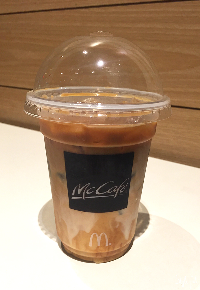 Image of a McCafe Classic Iced Coffee filled with cream, ice, milk and coffee in a plastic takeaway cup on a white background