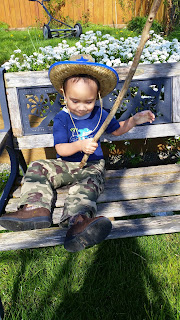 Toddler resting on a bench after trying to mow a lawn