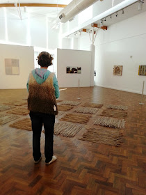 A woman standing in front of work at The Daylight Moon: an exhibition of Rosalie Gascoigne's  work, showing at Goulburn Regional Art Gallery.