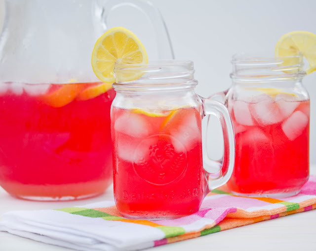 cranberry lemonade drink in a pitcher and two mason jar glasses